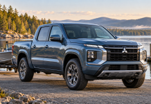 Mitsubishi Is Coming Back to the Pickup Market—But What Kind of Truck Will We Get? Blue Mitsubishi pickup concept inspired by the Nissan Frontier, shown from a front three-quarter angle with a small boat and trailer